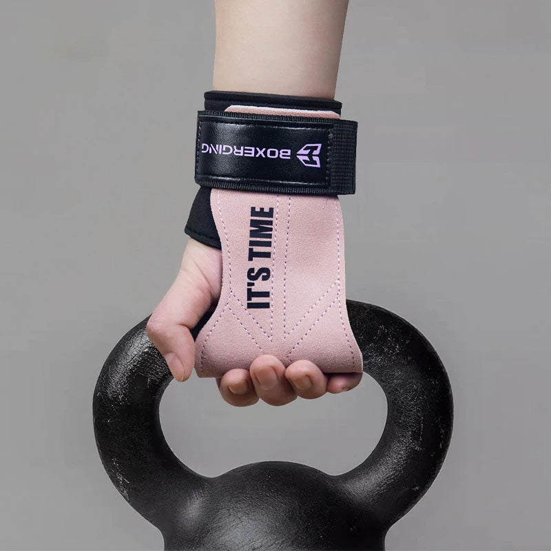 Hand wearing a pink wrist wrap with 'IT'S TIME' text, holding a black kettlebell against a gray background.